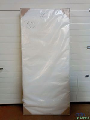 a white mattress in a room with a white wall