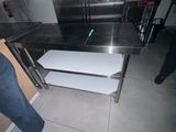 une table en acier inoxydable comportant deux étagères
