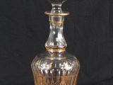 a clear glass bottle with a gold decoration on it