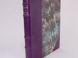 a purple book sitting on a white surface with a white background