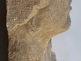 a stone sculpture of a woman ' s head on a white surface