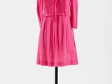 une robe rose posée sur un mannequin, sur fond blanc