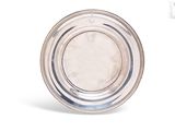 une plaque ovale en argent, bordée de perles, sur fond blanc