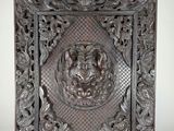 un panneau ancien en bois sculpté orné d'une tête de lion