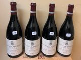 four bottles of red wine sitting on top of a wooden box