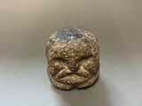 a close up of a statue of a face on a table