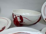 a lot of plates and bowls that have lobsters painted on them