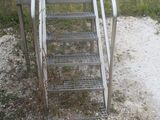 a metal staircase going up to the top of a hill