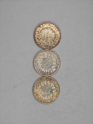 three gold and silver coins sitting on top of each other