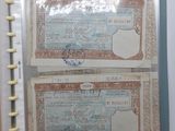 deux vieux billets de banque rangés dans un classeur posé sur une table