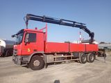 un gros camion rouge équipé d'une grue à l'arrière