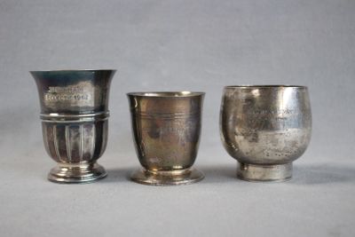 three silver cups sitting next to each other on a table