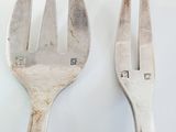 two forks that are sitting next to each other on a table