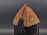 a brown hat with a blue tassel on top of it