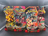 trois paquets de cartes Pokémon posés sur un canapé