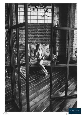 black and white photograph of a naked woman sitting on a couch in a room