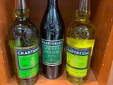 Plusieurs bouteilles d'alcool sont posées sur une étagère dans un magasin.