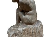statue of a man sitting on a rock with his head in his hands