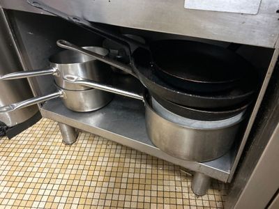 les casseroles et poêles qui se trouvent sur l'étagère de la cuisine