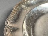 a silver plate on a table with a black background