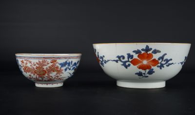two chinese porcelain bowls with floral designs on them on a black surface