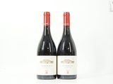deux bouteilles de vin rouge posées l'une à côté de l'autre sur une surface blanche