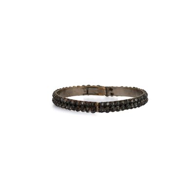 un gros plan d'un bracelet composé de perles noires sur fond blanc