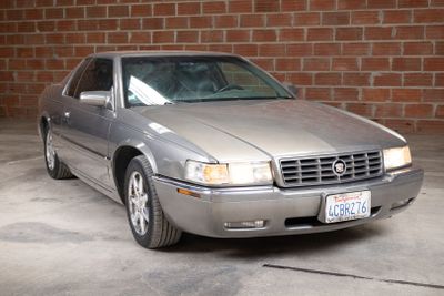 a silver car that is parked in front of a brick wall