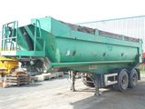 a green dump truck that is parked in a lot