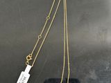a gold necklace with a brown stone pendant and a tag on it