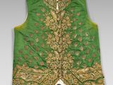 a close up of a green vest with gold embroidery on it