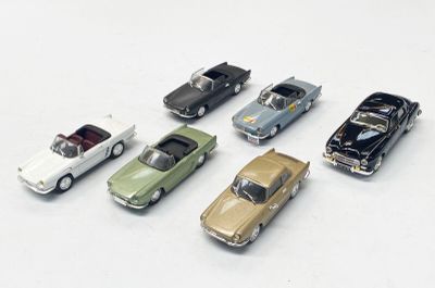 plusieurs petites voitures sont alignées sur une surface blanche