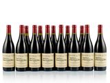 six bottles of wine lined up in a row on a white surface