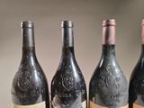 four bottles of wine are lined up on a table