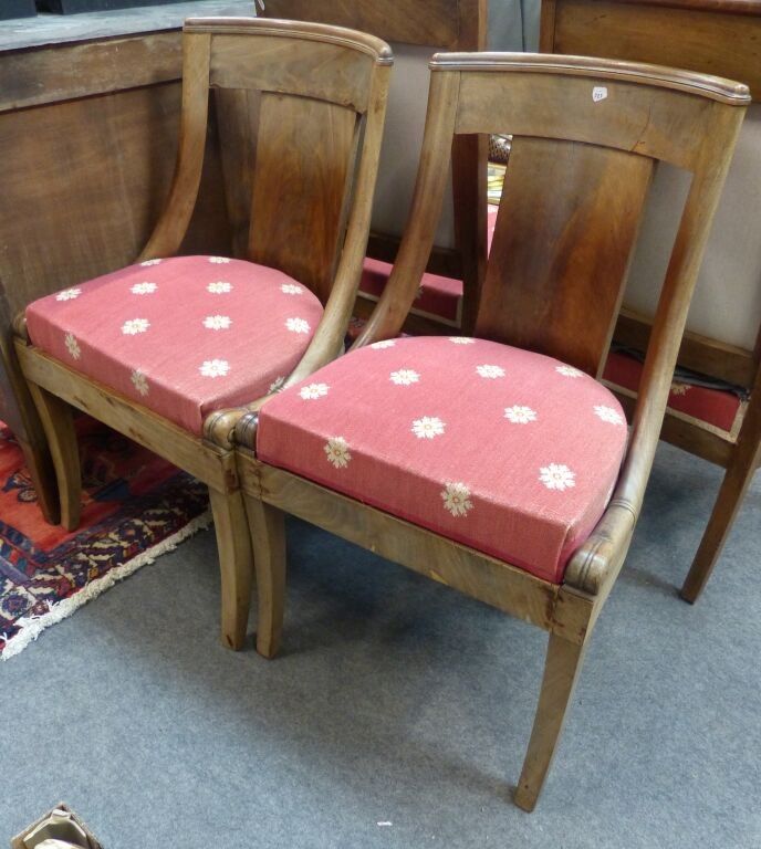 Paire de chaises en acajou et placage acajou. Le dossier incurvé à décor d'enroulements reposant sur quatre pieds sab...