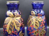 deux vases bleus ornés de motifs dorés, posés sur une table