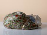 a figurine of a cat laying down on a table