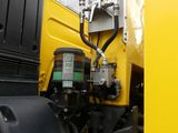 a close up of a yellow truck with a black engine