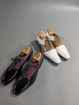 two pairs of shoes sitting on top of a table next to each other