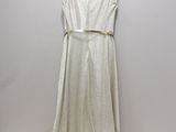 the white dress is hanging on a hanger on the wall