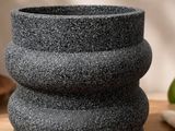 un gros plan d'un vase en pierre noire posé sur une table
