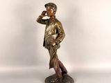 bronze statue of a man with a hat and jacket on a white background