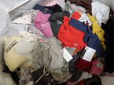a pile of clothes that is sitting on a bed
