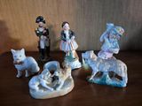 cinq figurines représentant des personnes et des animaux posées sur une table