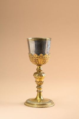 an antique silver and gold goblet on a beige background