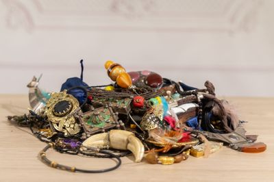 a pile of assorted jewelry on a wooden table
