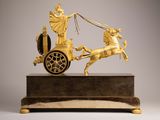 an image of a gold statue of a chariot with a man on it