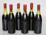 six bottles of wine lined up in a row on a table