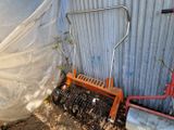 une photo d'un petit outil de jardinage appuyé contre un mur