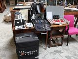 un bureau sur lequel se trouvent un ordinateur portable, une valise et d'autres objets